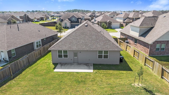 back of house with a lawn and a patio