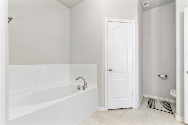 bathroom featuring a washtub and toilet