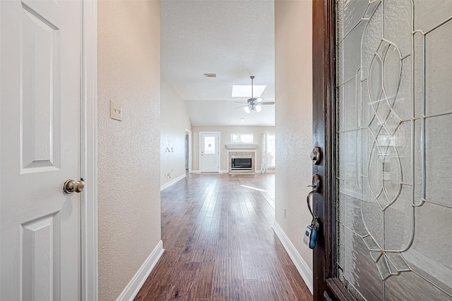 foyer entrance with ceiling fan, wood-type flooring, a textured ceiling, and lofted ceiling