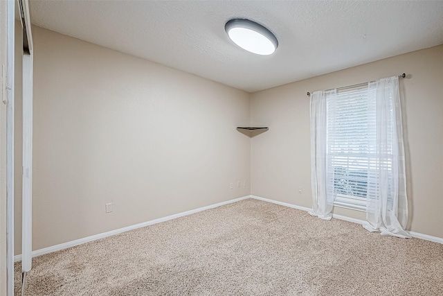 carpeted empty room with a textured ceiling