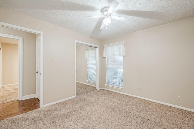 unfurnished bedroom with ceiling fan, a textured ceiling, a closet, and carpet floors