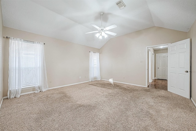 unfurnished room with ceiling fan, lofted ceiling, and carpet flooring