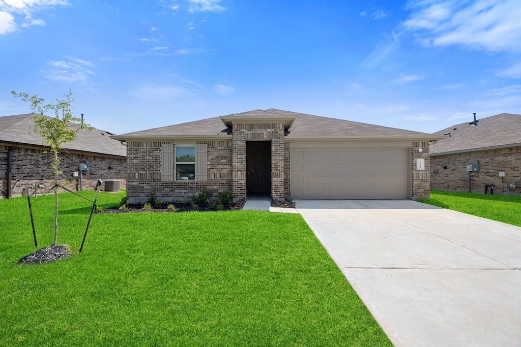 view of front of property featuring a front lawn, central AC unit, and a garage