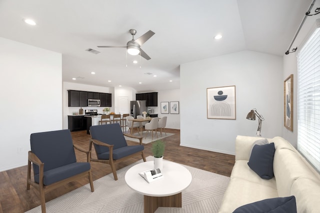 living room with hardwood / wood-style flooring, ceiling fan, and vaulted ceiling