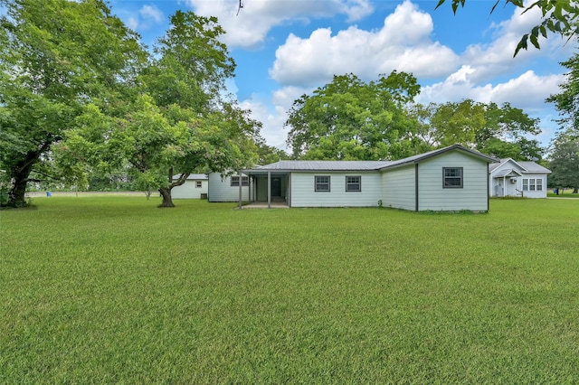 rear view of house featuring a yard