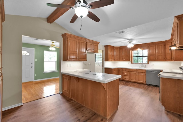 kitchen featuring hardwood / wood-style floors, lofted ceiling with beams, sink, stainless steel dishwasher, and kitchen peninsula