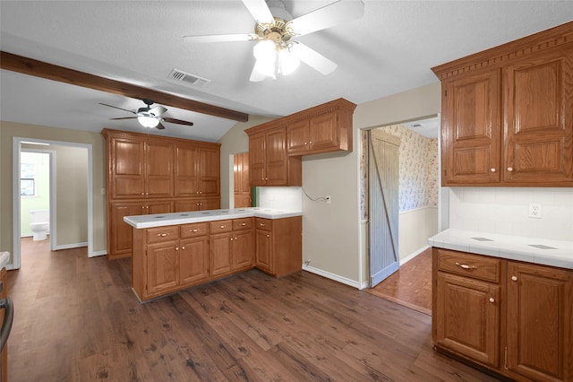 kitchen with kitchen peninsula, lofted ceiling with beams, dark hardwood / wood-style floors, and ceiling fan