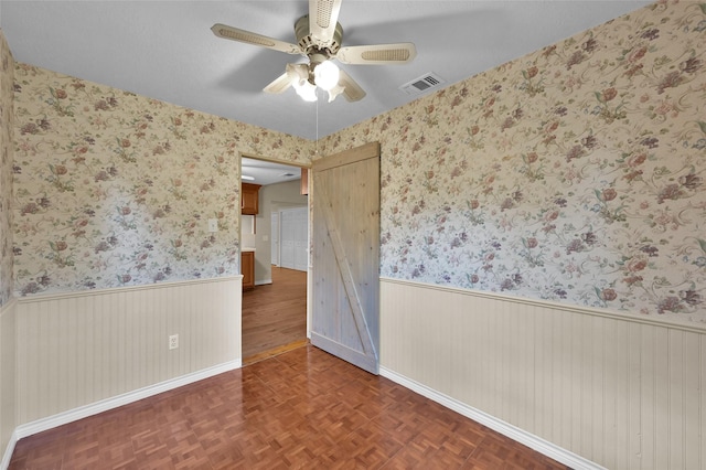 empty room featuring dark parquet floors and ceiling fan