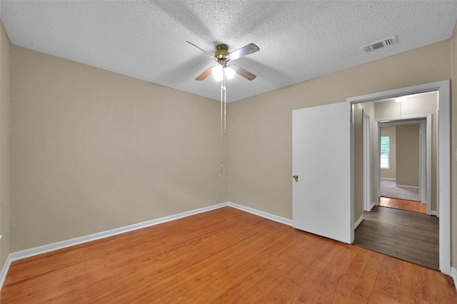 unfurnished room featuring hardwood / wood-style floors, ceiling fan, and a textured ceiling