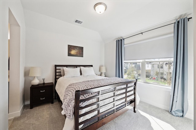 bedroom with light colored carpet and lofted ceiling