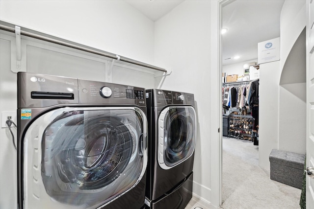 clothes washing area with separate washer and dryer and light colored carpet