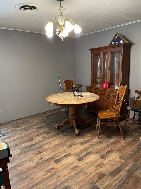 dining room featuring ornamental molding, dark hardwood / wood-style floors, and a notable chandelier