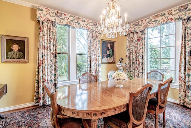 dining space with crown molding, hardwood / wood-style floors, and a notable chandelier