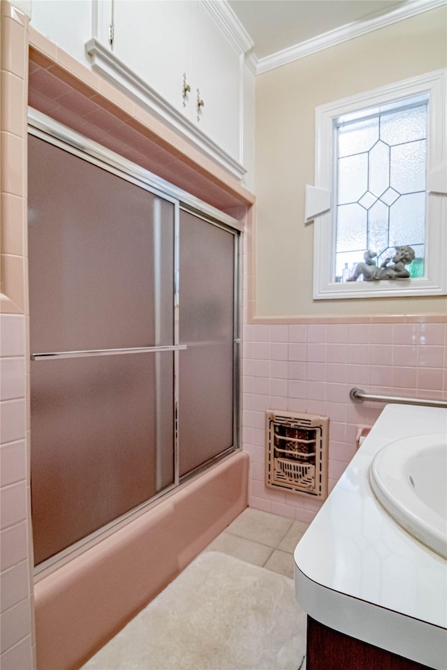 bathroom featuring vanity, tile patterned flooring, enclosed tub / shower combo, ornamental molding, and heating unit