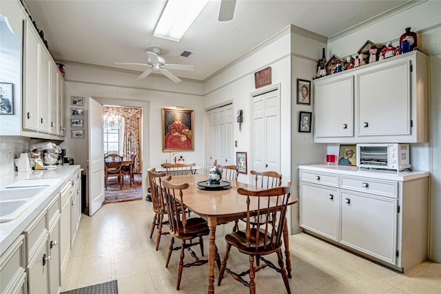 dining room with ceiling fan, ornamental molding, and sink