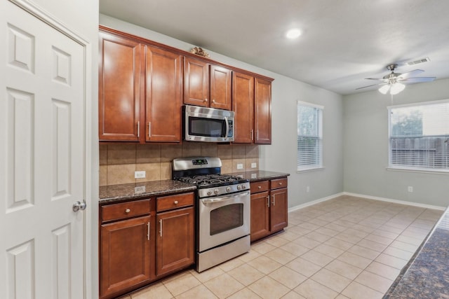 kitchen featuring decorative backsplash, light tile patterned floors, stainless steel appliances, and ceiling fan