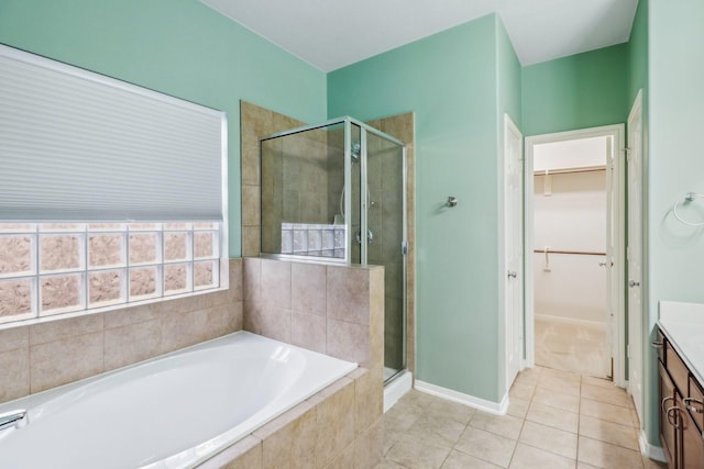 bathroom with plus walk in shower, tile patterned flooring, and vanity