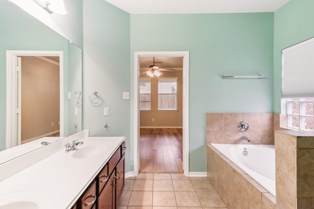 bathroom featuring tiled bath, a wealth of natural light, tile patterned flooring, and ceiling fan