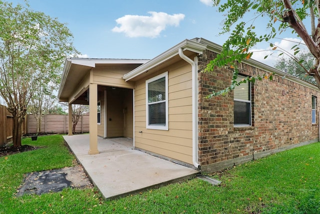 view of property exterior with a lawn and a patio area