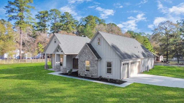 rear view of property with a garage and a lawn