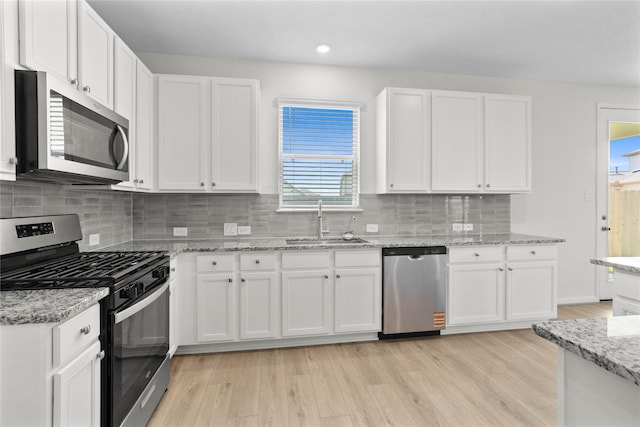 2836 Shimmer Edge Dr, Katy, TX 77493 - kitchen with a sink, white cabinetry, tasteful backsplash, and stainless steel appliances