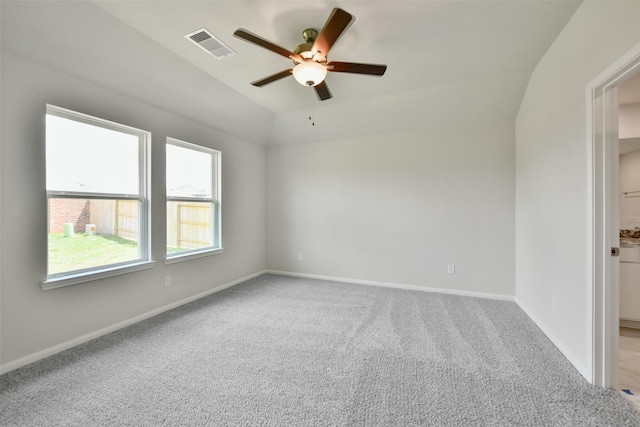 carpeted spare room featuring ceiling fan and vaulted ceiling