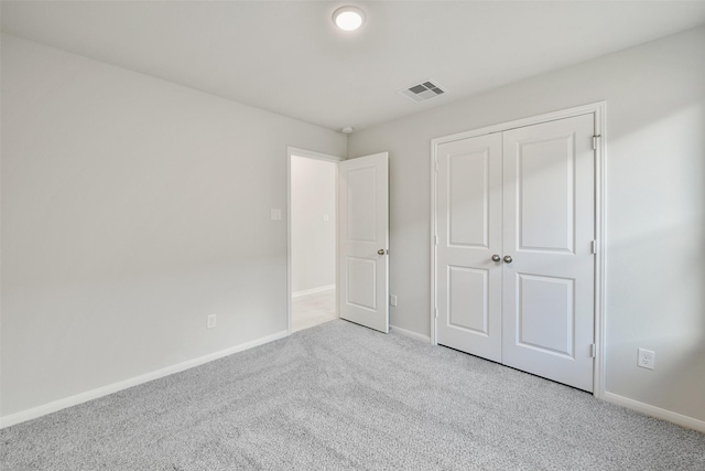 unfurnished bedroom featuring a closet and light colored carpet