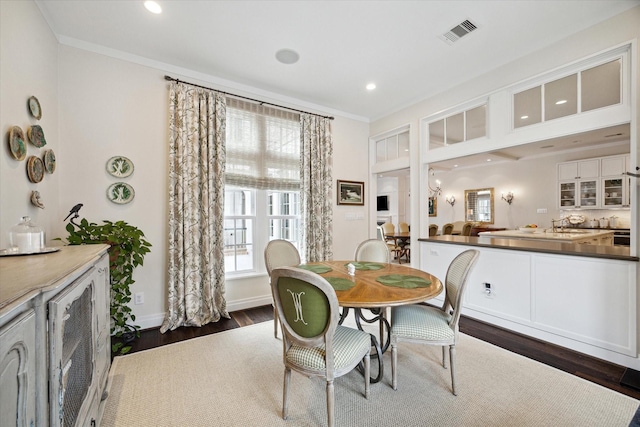 dining area featuring dark hardwood / wood-style floors and ornamental molding