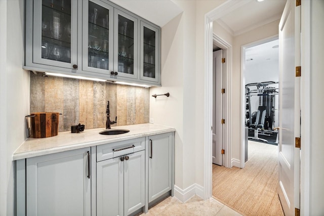 bar with gray cabinetry, sink, decorative backsplash, light stone countertops, and light tile patterned flooring