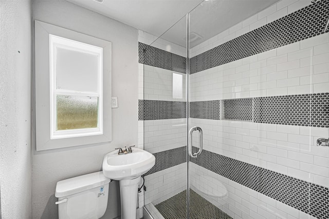 bathroom with toilet and a shower with shower door