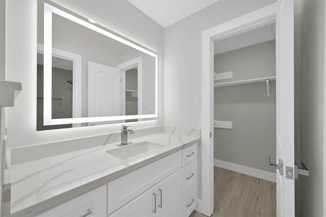 bathroom with a shower, vanity, and hardwood / wood-style flooring