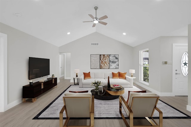 living room featuring ceiling fan, lofted ceiling, and light hardwood / wood-style flooring