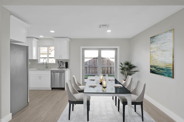 dining room featuring light hardwood / wood-style floors, a healthy amount of sunlight, and sink