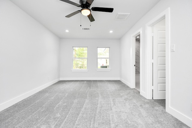 empty room with ceiling fan and light carpet