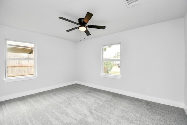 carpeted spare room featuring ceiling fan