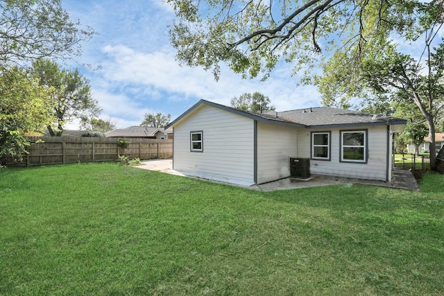 back of property with cooling unit and a lawn