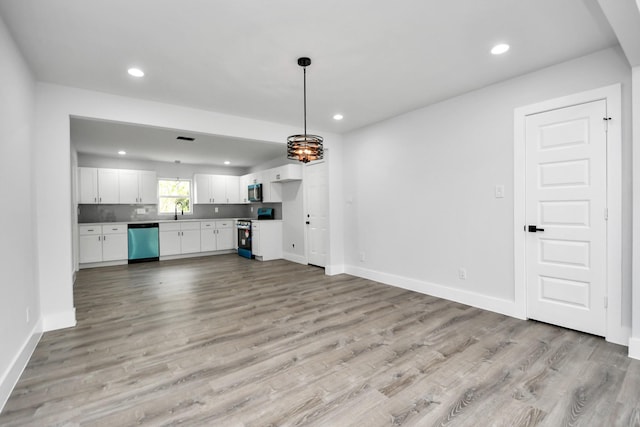 unfurnished living room featuring sink and light hardwood / wood-style flooring