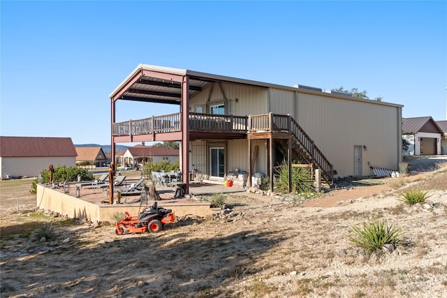 back of house featuring a wooden deck and a patio area