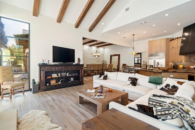 living room featuring vaulted ceiling with beams and a chandelier