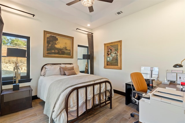 bedroom with a tray ceiling and ceiling fan