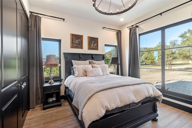 bedroom featuring light hardwood / wood-style floors and an inviting chandelier