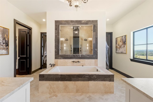 bathroom featuring a chandelier, vanity, and separate shower and tub