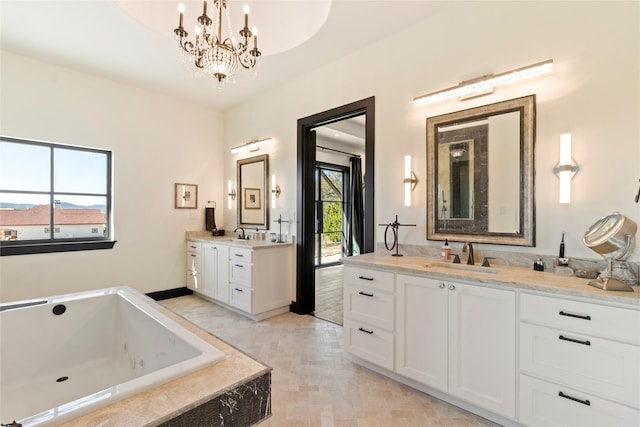 bathroom with tiled bath, vanity, and an inviting chandelier