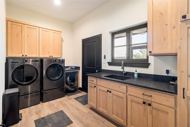 laundry room with light hardwood / wood-style floors, sink, cabinets, and independent washer and dryer