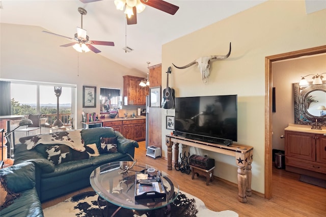 living room with light hardwood / wood-style floors, ceiling fan, and lofted ceiling