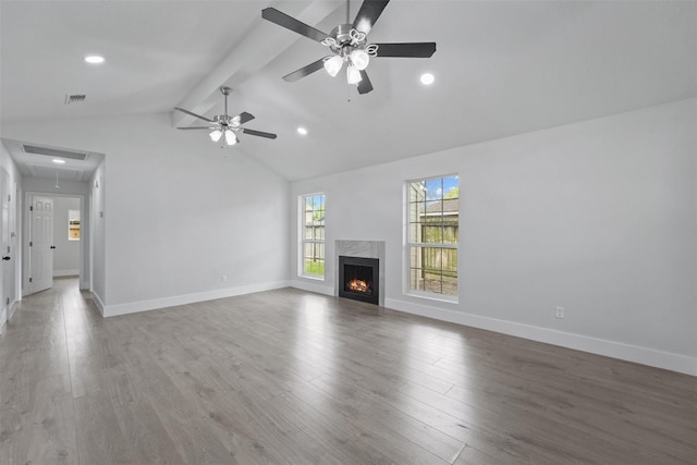 unfurnished living room with hardwood / wood-style floors, lofted ceiling with beams, ceiling fan, and a high end fireplace