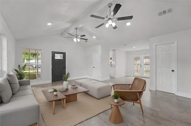 living room with vaulted ceiling with beams, ceiling fan, french doors, and light hardwood / wood-style flooring