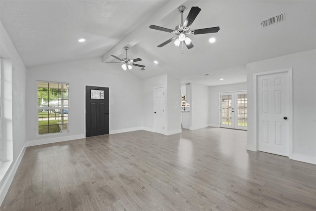 unfurnished living room with vaulted ceiling with beams, light hardwood / wood-style floors, ceiling fan, and french doors