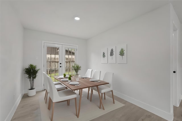 dining room featuring light wood-type flooring and french doors