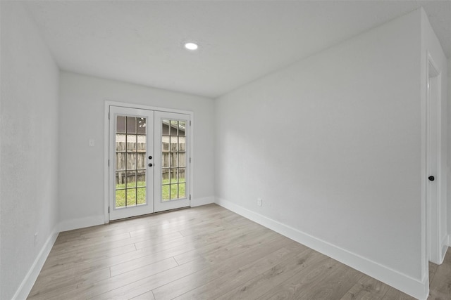 spare room with light hardwood / wood-style floors and french doors